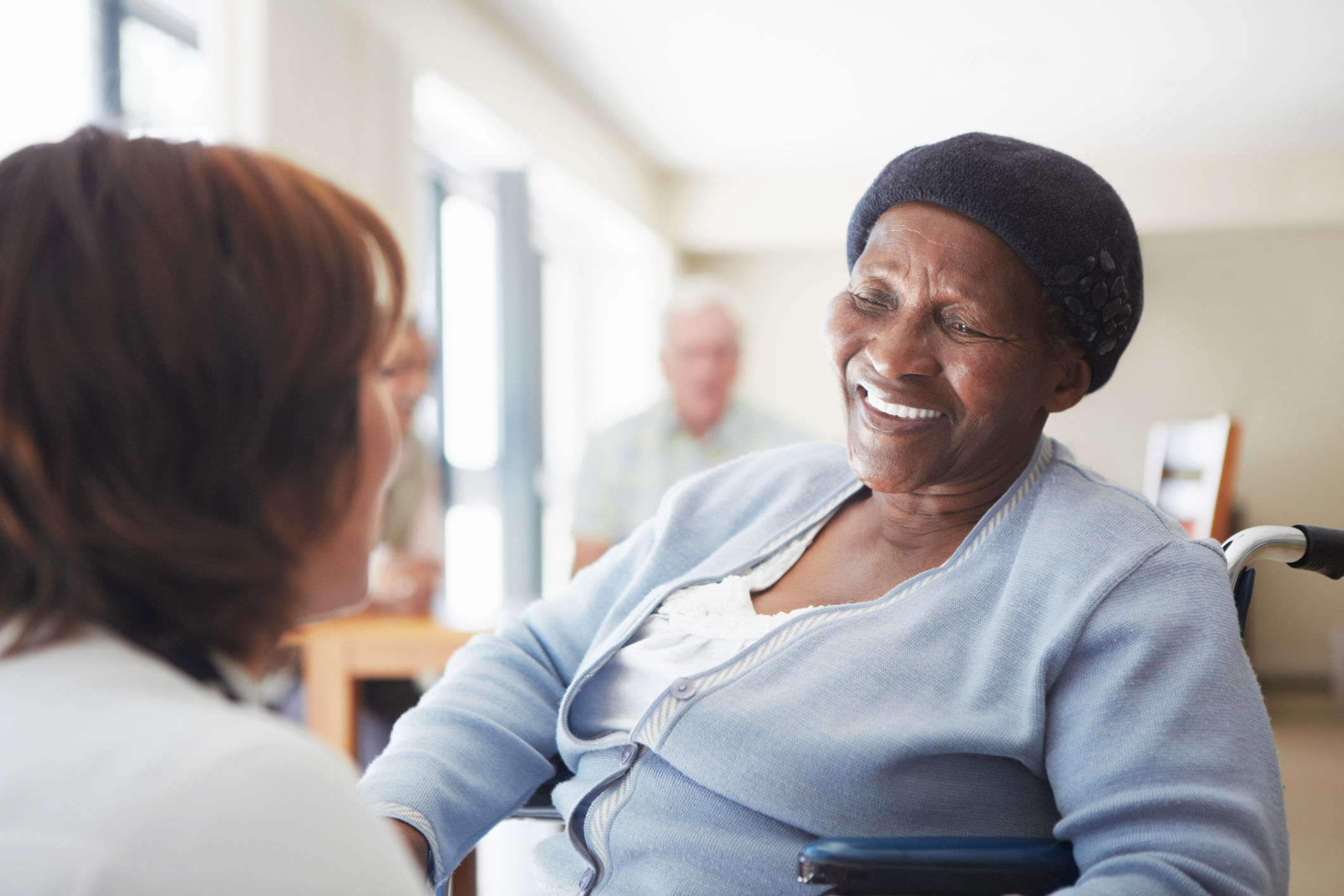 A caregiver talking to a wheelchair-bound patient